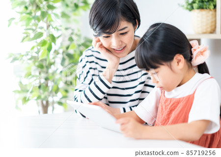 Parents and children (mother and child) enjoying the Internet on a tablet 85719256