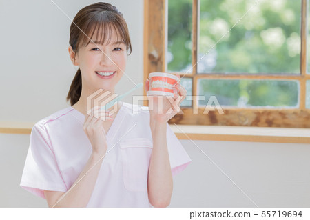 Dental hygienist giving a lecture on how to brush teeth 85719694
