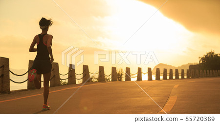 Woman runner  running at sunrise seaside 85720389