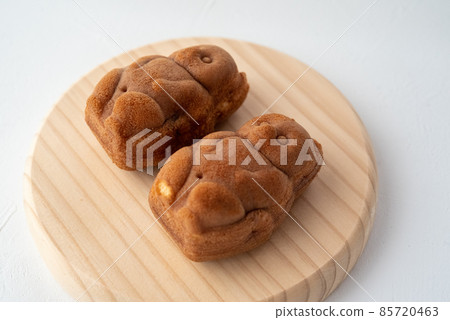 Two raccoon dogs lined up on a wooden plate Two raccoon dogs lined up on a wooden plate 85720463