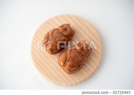 Two raccoon dogs lined up on a wooden plate Two raccoon dogs lined up on a wooden plate 85720465