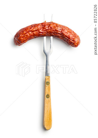 Smoked sausage pricked on a fork. 85722826
