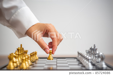 Human hand moving gold chess figure at table, Success, management, business planning, leadership, Business Strategy and tactic Concept. Human hand moving gold chess figure at table, Success, management, business planning, leadership, Business Strategy and tactic Concept. 85724086
