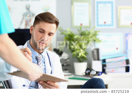 Man doctor in personal cabinet put signature of medical paper Man doctor in personal cabinet put signature of medical paper 85725219