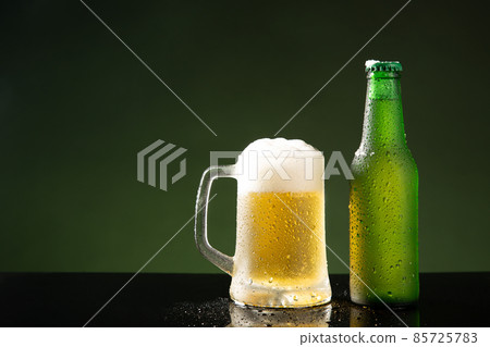 Beer mug and bottle on green background with copyspace. Beer mug and bottle on green background with copyspace. 85725783