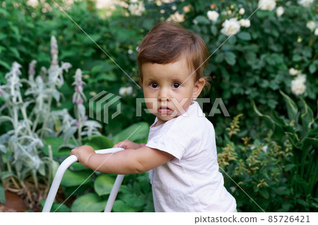 Toddler little caucasian girl in white t-shirt in the garden staining 85726421