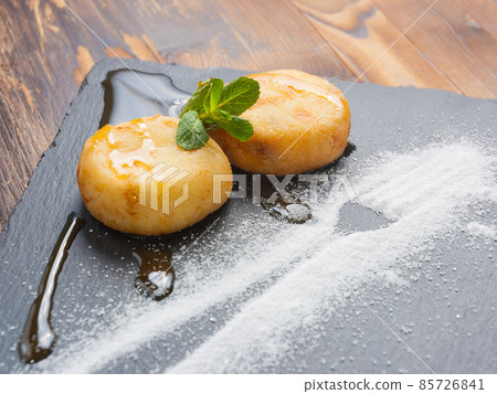 cheese pancakes with caramel sauce, powdered sugar and mint cheese pancakes with caramel sauce, powdered sugar and mint 85726841