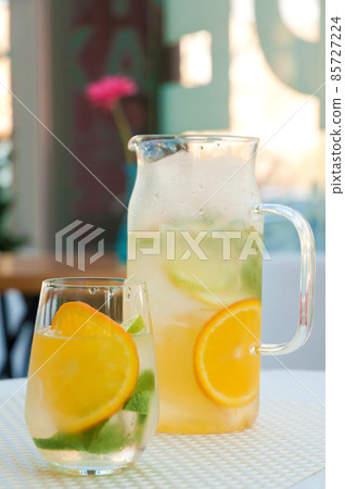 cold lemonade in a decanter and in a glass cold lemonade in a decanter and in a glass 85727224