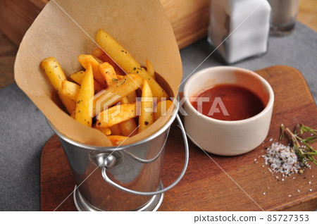 French fries in a metal bucket with tomato sauce French fries in a metal bucket with tomato sauce 85727353