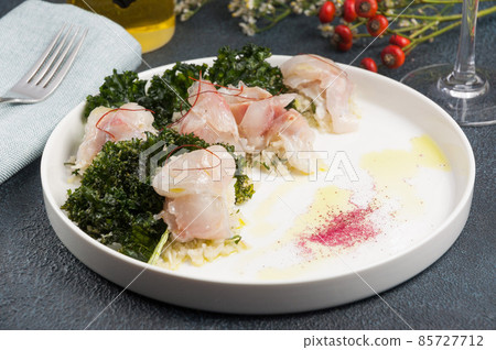 slice of raw white fish with seaweed and red pepper straws 85727712