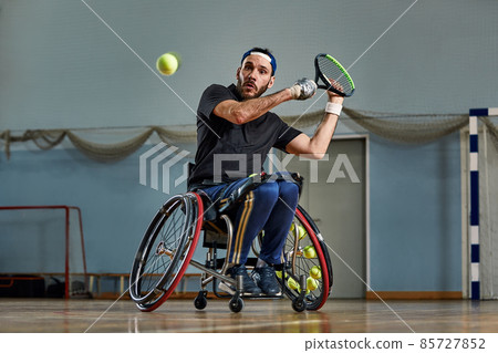 Young man in wheelchair playing tennis on court. Wheel Chair Tennis. 85727852