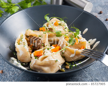 traditional Eastern dish manti or manty with beef in a dark plate 85727905