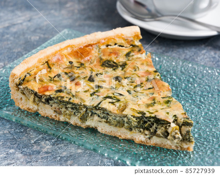 slice of tasty spinach pie on a glass plate slice of tasty spinach pie on a glass plate 85727939