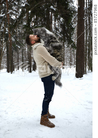 Men playing with siberian husky in winter forest and park, animals and ecology. Pet lover. Dog - human s friend concept 85727968