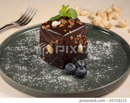 cake with chocolate and nuts in chocolate glaze 85728215