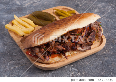 Turkish Doner with veal in bread with French fries, pickles Turkish Doner with veal in bread with French fries, pickles 85728230