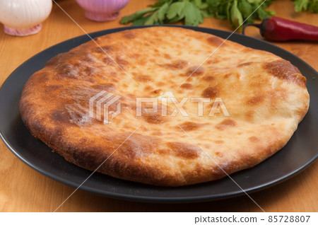 traditional Georgian cuisine. Imereti khachapuri on a dark plate traditional Georgian cuisine. Imereti khachapuri on a dark plate 85728807