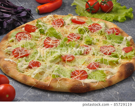 Caesar pizza on a gray background decorated with vegetables 85729119