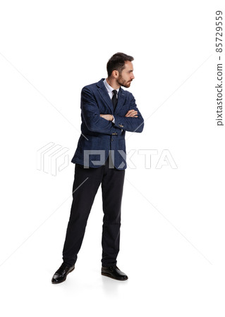 Full-length portrait of businessman with curious and concentrated facial expression controlling projects isolated over white background 85729559