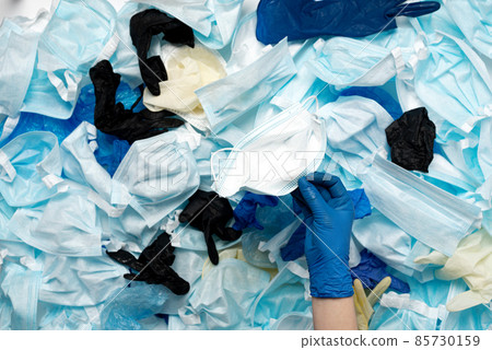 Waste of used personal protective equipment PPE, gloves, disposable masks, shoe covers of medical workers. Garbage contamination after the COVID-19 pandemic Waste of used personal protective equipment PPE, gloves, disposable masks, shoe covers of medical workers. Garbage contamination after the COVID-19 pandemic 85730159