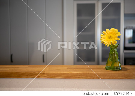 Yellow gerbera flowers on the counter of a newly built detached kitchen 85732140