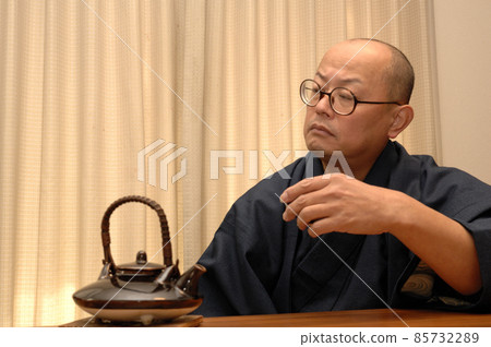 Middle-aged man relaxing in kimono Middle-aged man relaxing in kimono 85732289