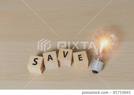 Word "save" on wooden cube blocks with Light bulb. eco environment. Save power energy concept. 85733691