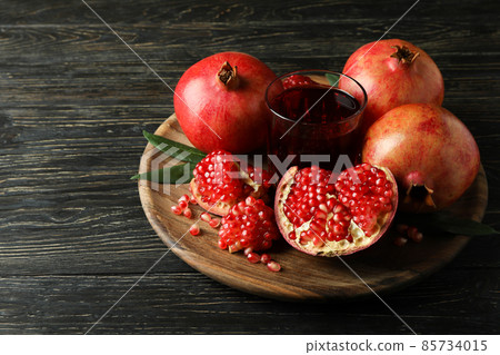 Board with pomegranate juice and ingredients on wooden table Board with pomegranate juice and ingredients on wooden table 85734015