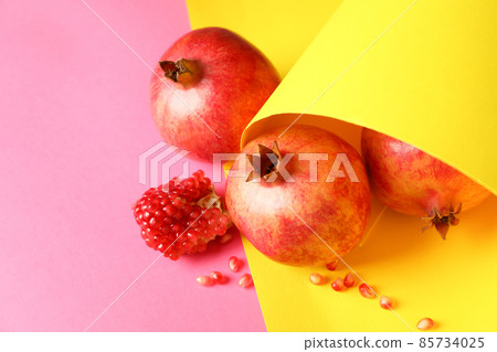Ripe pomegranate fruits on two tone background Ripe pomegranate fruits on two tone background 85734025