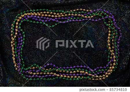 Frame of colorful Mardi Gras Beads on black background Frame of colorful Mardi Gras Beads on black background 85734810