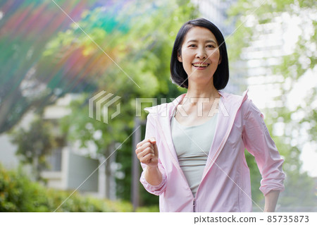 Middle-aged woman walking in sportswear Middle-aged woman walking in sportswear 85735873