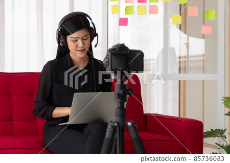 Vlog Asian woman blogger influencer sitting on the sofa in home and recording video blog for teaching and coach her Students or subscriber. Concept of the content creator online for a new lifestyle Vlog Asian woman blogger influencer sitting on the sofa in home and recording video blog for teaching and coach her Students or subscriber. Concept of the content creator online for a new lifestyle 85736083