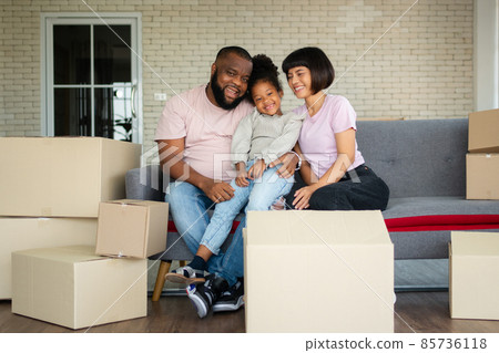 Mixed Race families are sitting on the sofa for rest after moving to a new house on the first day after buying real estate. Concept of starting a new life for a new family. Mixed Race families are sitting on the sofa for rest after moving to a new house on the first day after buying real estate. Concept of starting a new life for a new family. 85736118
