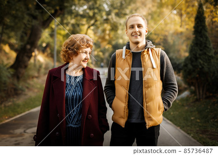 Russian caucasian mature mother with her adult son walking autumn outdoor Russian caucasian mature mother with her adult son walking autumn outdoor 85736487