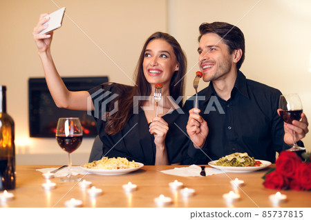 Smiling woman taking selfie with boyfriend on a date Smiling woman taking selfie with boyfriend on a date 85737815