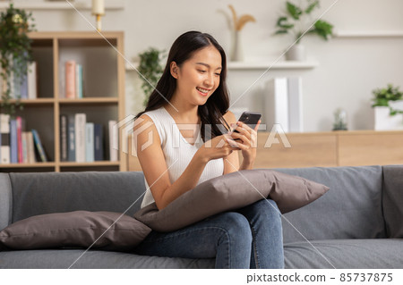 Happiness Entrepreneur beautiful business asian young woman wear casual use mobile phone for shopping online enjoy with social media and laptop at home.Small Business Startup.online banking 85737875