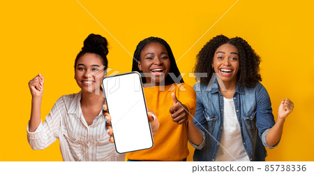 Three emotional black ladies gesturing on yellow, showing cellphone, mockup Three emotional black ladies gesturing on yellow, showing cellphone, mockup 85738336
