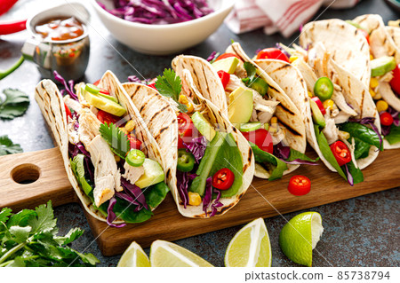 Chicken tacos with grilled meat, avocado, fresh vegetable salad and sauce salsa Chicken tacos with grilled meat, avocado, fresh vegetable salad and sauce salsa 85738794