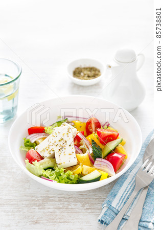 Fresh summer vegetable salad with lettuce, tomato, cucumber, bell pepper, onion and feta cheese, dressed with olive oil Fresh summer vegetable salad with lettuce, tomato, cucumber, bell pepper, onion and feta cheese, dressed with olive oil 85738801