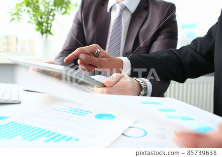 Two businessmen looking and studying analytics and business statistics Two businessmen looking and studying analytics and business statistics 85739638