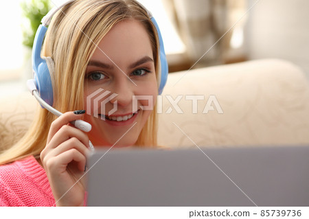 Portrait happy woman in headphones talking online with client via digital webcam 85739736