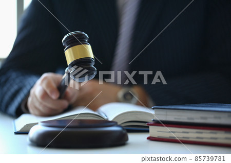 Male judge in courtroom hits with hammer Male judge in courtroom hits with hammer 85739781