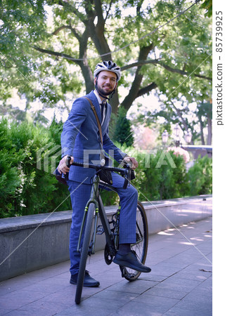 Bearded businessman in suit and helmet with bike. 85739925