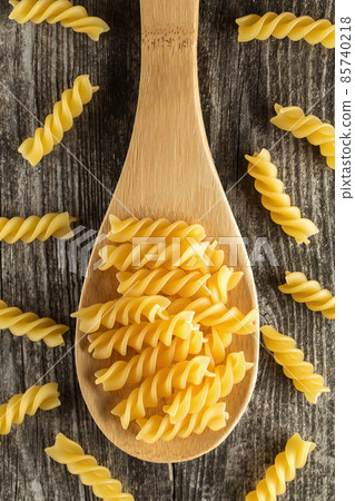 Fusilli italian pasta on wooden spoon 85740218