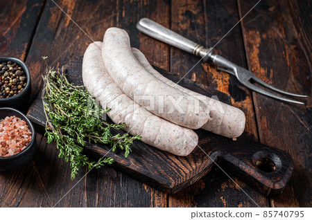 Munich traditional white sausages on a wooden board with thyme. Dark wooden background. Top view 85740795