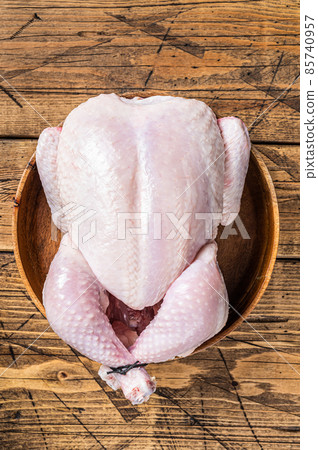 Raw chicken, poultry meat in wooden plate. Wooden background. Top view Raw chicken, poultry meat in wooden plate. Wooden background. Top view 85740957