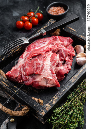Lamb or mutton neck meat, raw Boneless meat in wooden tray. Black background. Top view 85740969