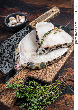 Fresh Raw wolffish o wolf fish Steak on a butcher board. Dark wooden background. Top view 85741329
