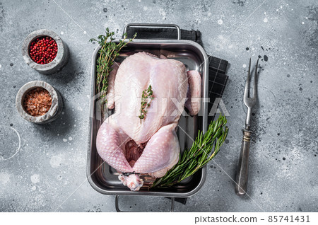 Whole raw Free range chicken in kitchen tray with herbs. Gray background. Top view Whole raw Free range chicken in kitchen tray with herbs. Gray background. Top view 85741431