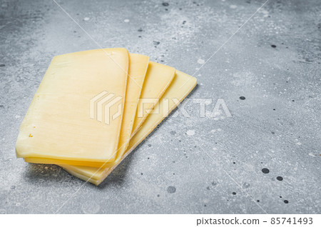Uncooked Raclette Swiss cheese slices. Gray background. Top view. Copy space 85741493